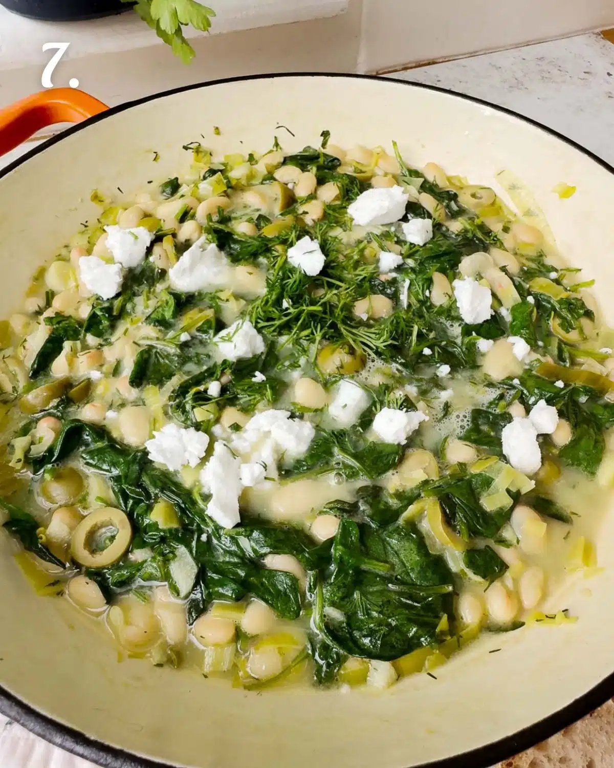 Finish the dish with a sprinkle of vegan feta, a drizzle of extra virgin olive oil and some fresh herbs. The spanakopita beans are ready to eat.