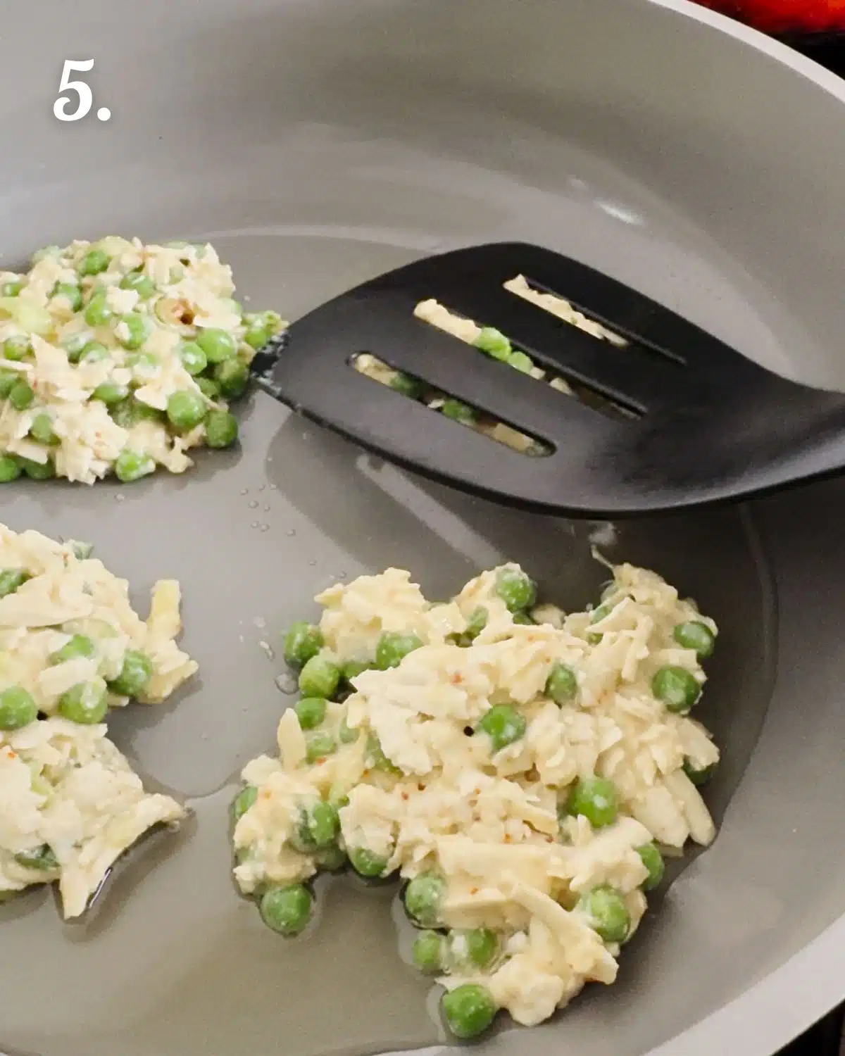 Flatten the fritters with the back of a spatula and let cook before flipping over.