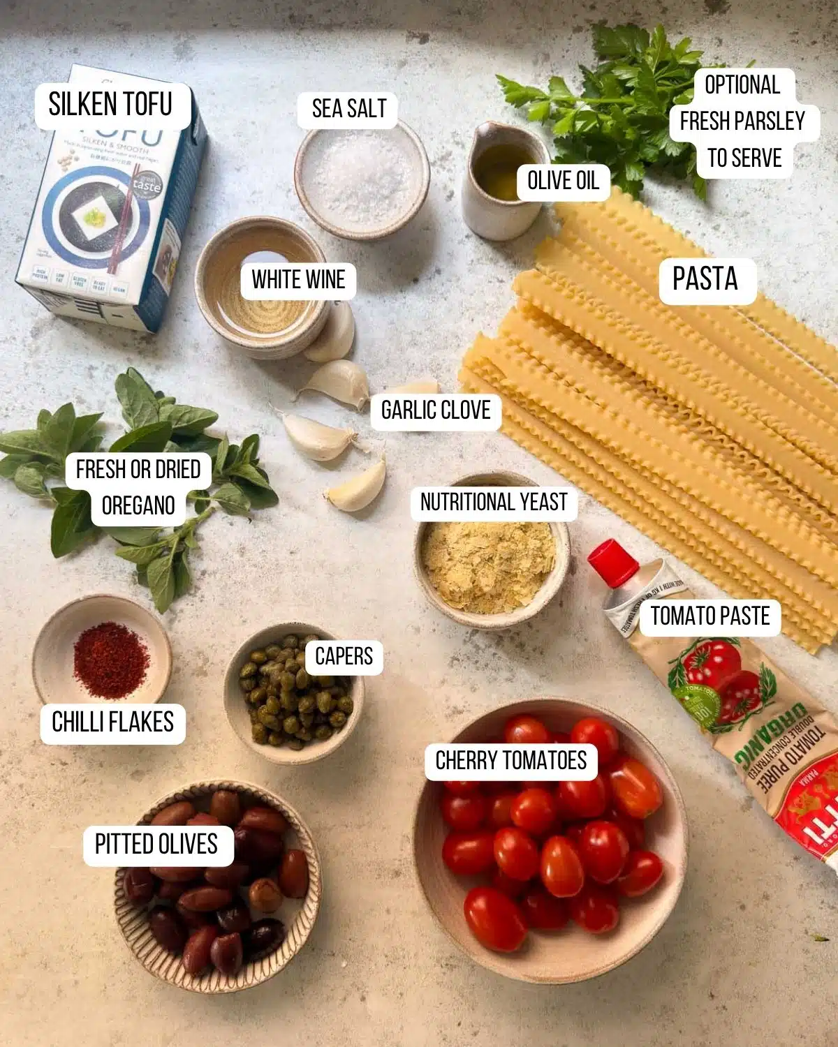 Ingredients for the creamy tomato pasta puttanesca laid out ready to use.