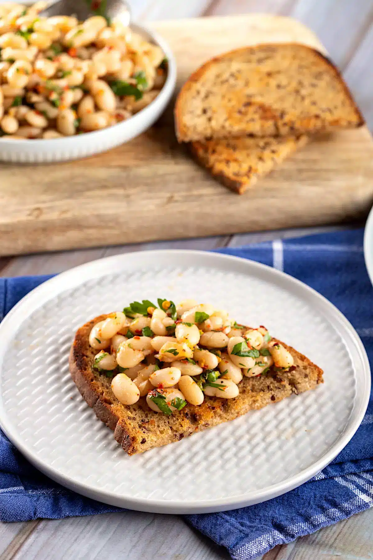 Toasts with white beans that have been cooked in garlic and rosemary served as a canape.