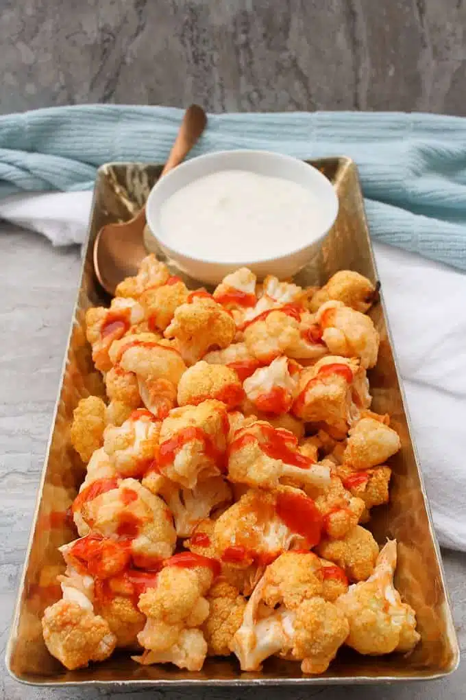 Buffalo Cauliflower Wings on a platter with some dip ready to eat.