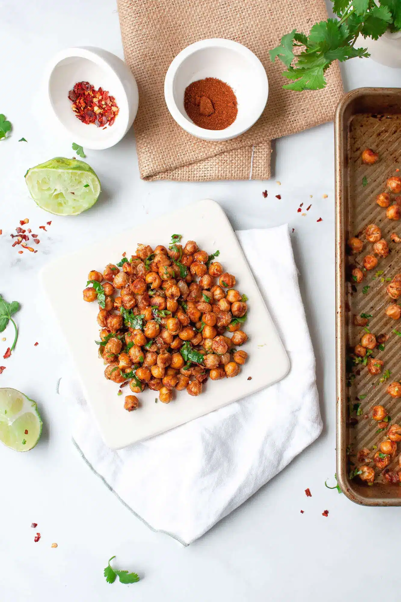 Chili lime roasted chickpeas on a plate with some spices next to it.