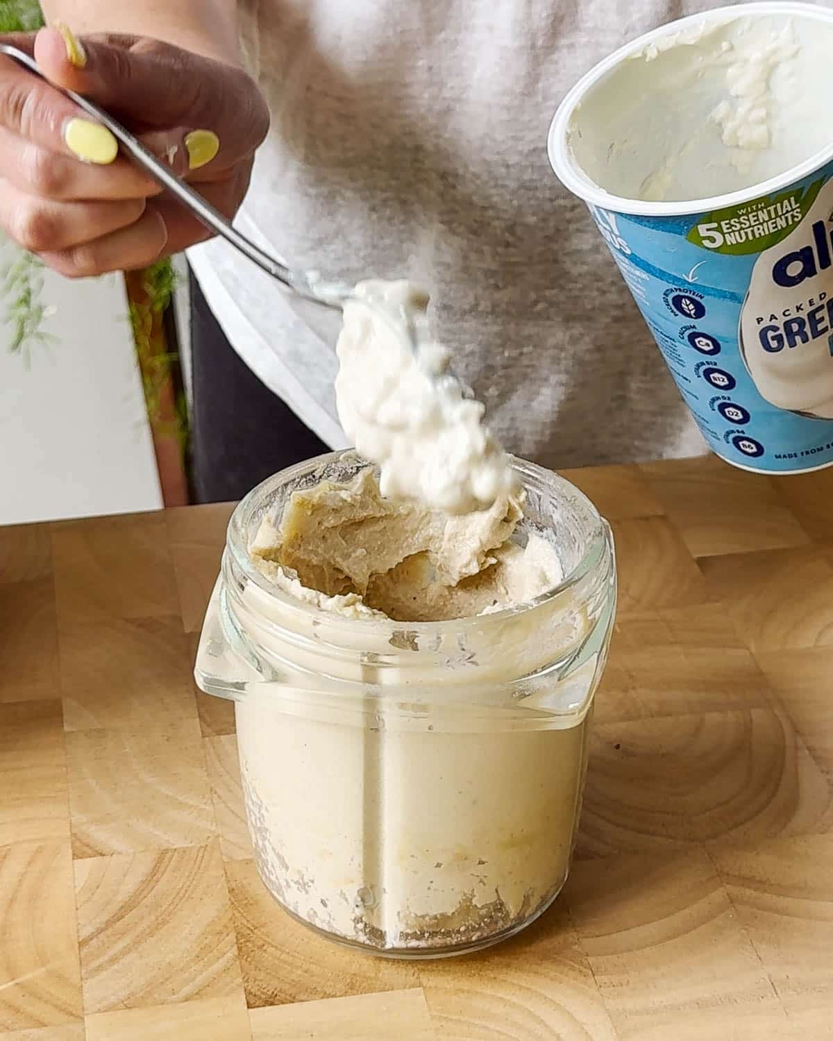 Showing adding the vegan yoghurt to the blender.