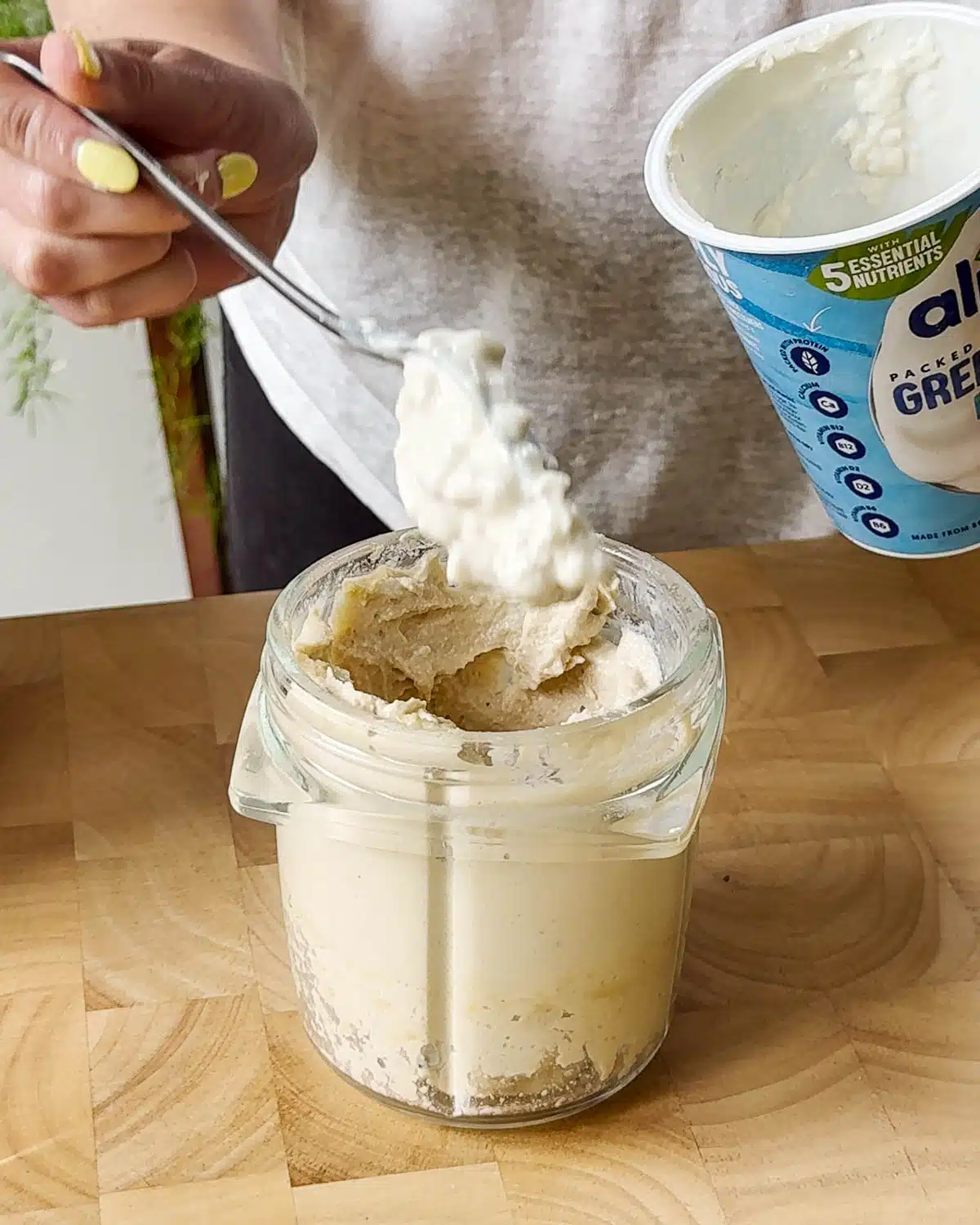 Showing adding the vegan yoghurt to the blender.