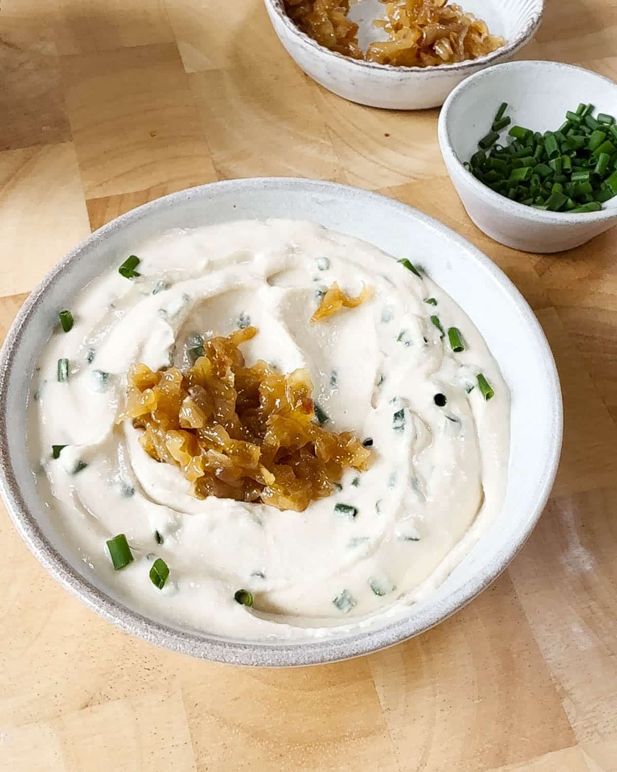 Showing the dip with the chives in it, topped with the caramelised onions.
