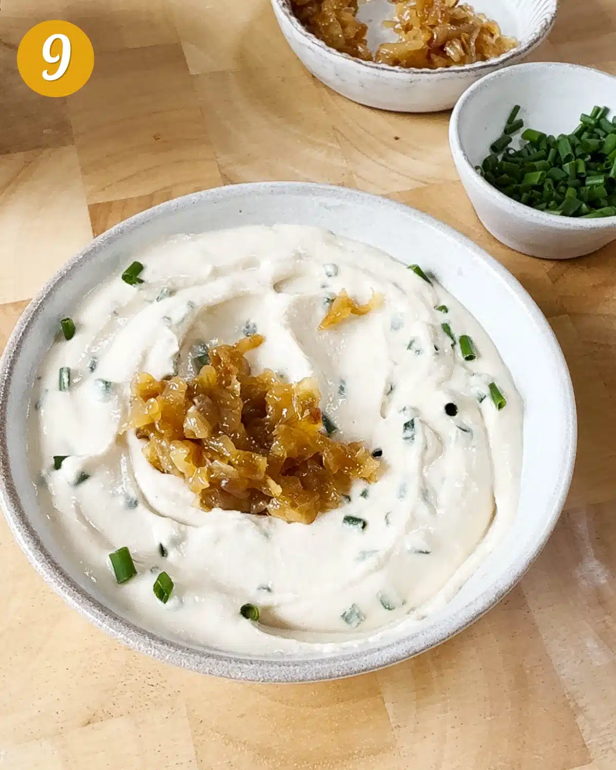 Showing the vegan cream cheese dip with chives mixed into it and caramelised onions on top.