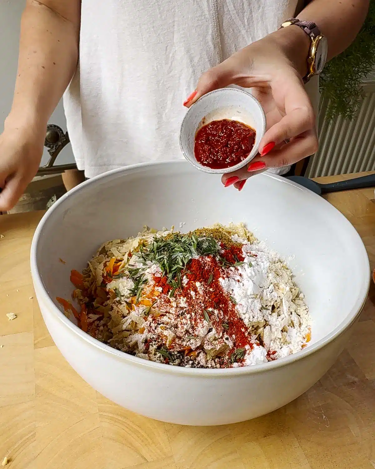 Add the spices, harissa and flours to the bowl.