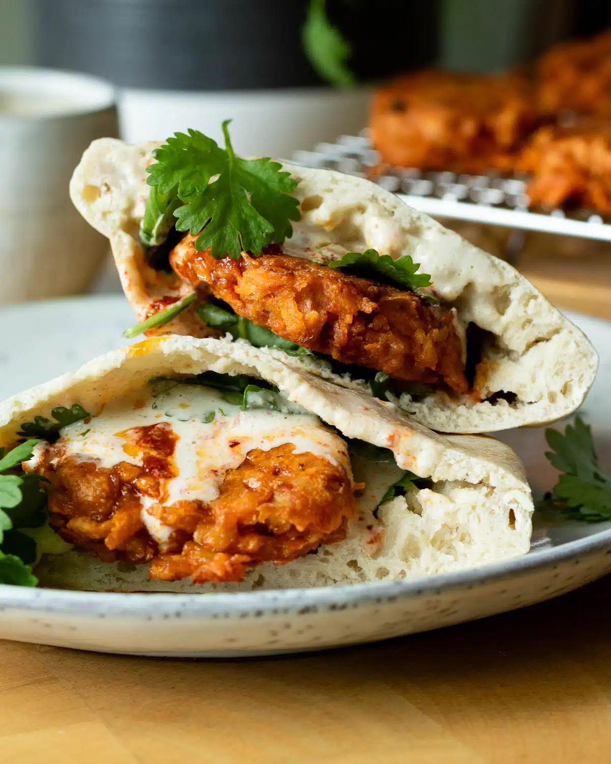 Carrot and Tempeh fritters in a pita bread with arugula, coriander leaf and tahini sauce.