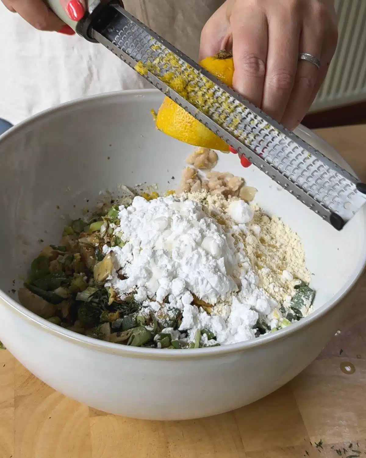 Zesting the lemon into the crab cake mixture before mixing.