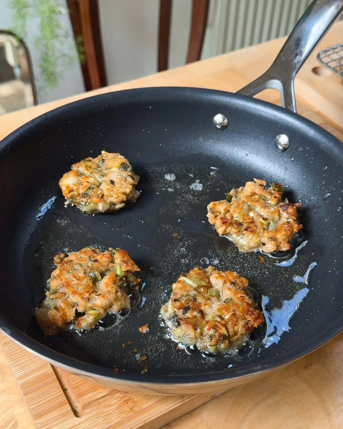 Pan frying the crab cakes until crispy.