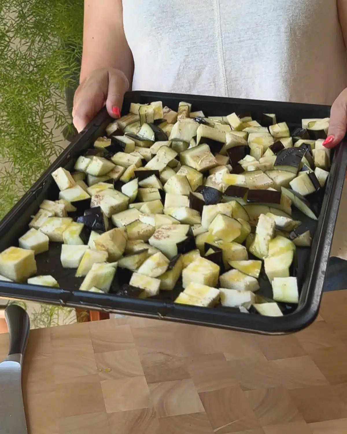 Cut the eggplant into 2-3 cm cubes. Spray with oil and put on a tray in the oven to bake.