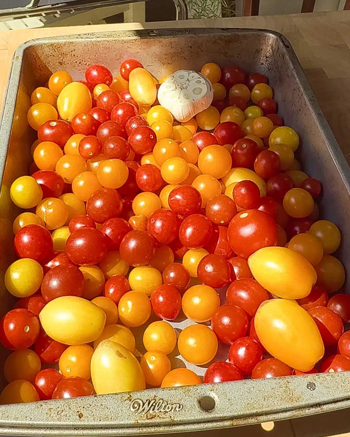 Add cherry tomatoes or regular tomatoes to a baking tray.