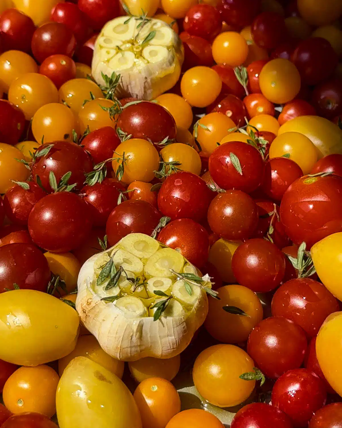 Cut the top off garlic and drizzle with oil. Add seasonings and oil to tomatoes and mix.