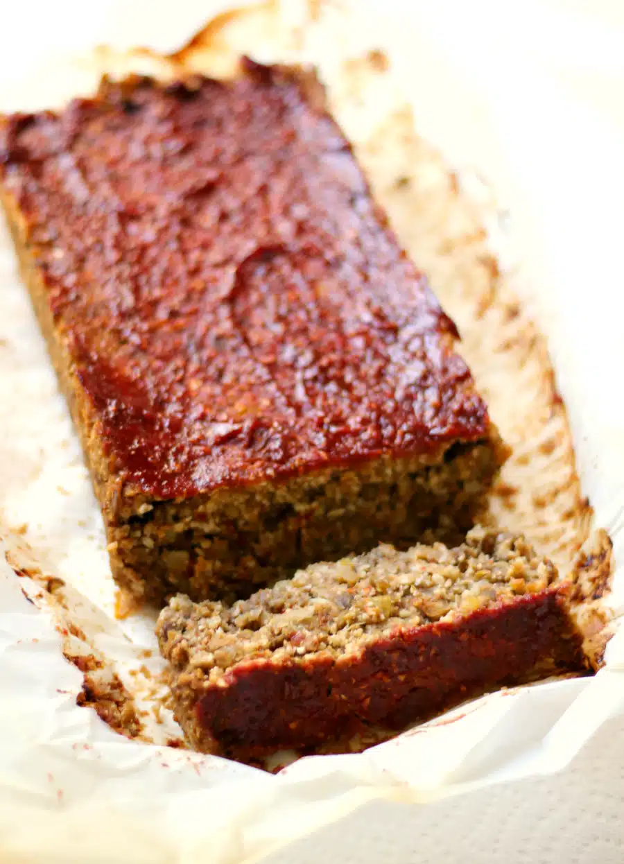 Lentil and Cauliflower loaf with a ketchup topping and a slice taken from it.