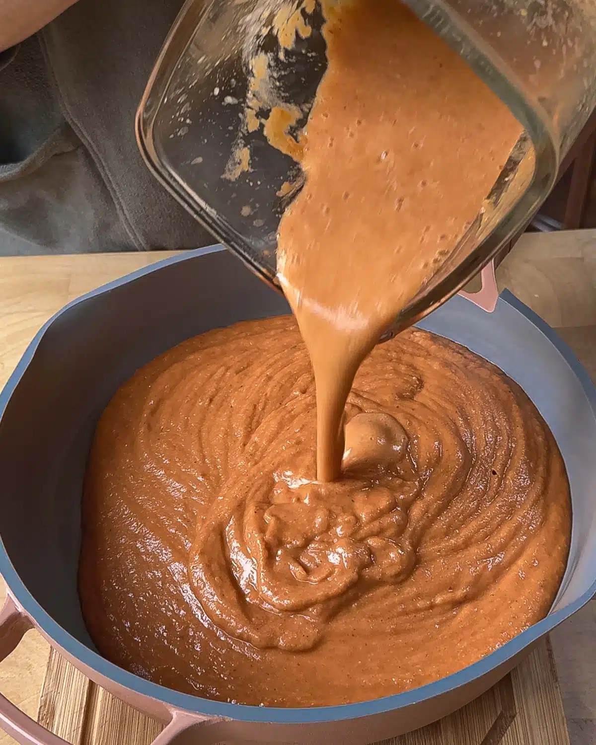 The soup has been blended and is being poured into a large sauce pan to reaheat and check for seasonings.