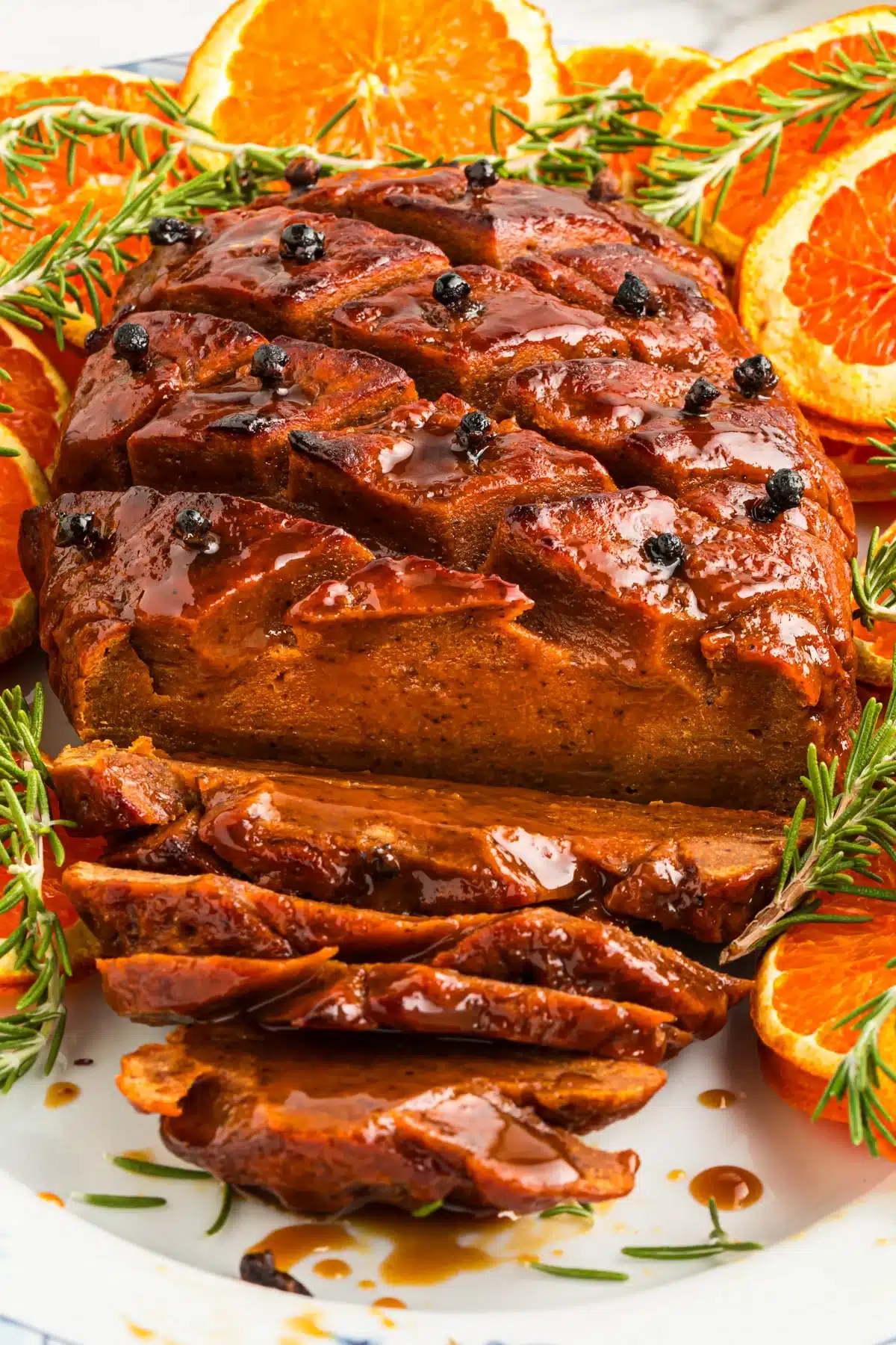 Smoky and spectacular seitan ham to make for the holidays with some orange slices around it.